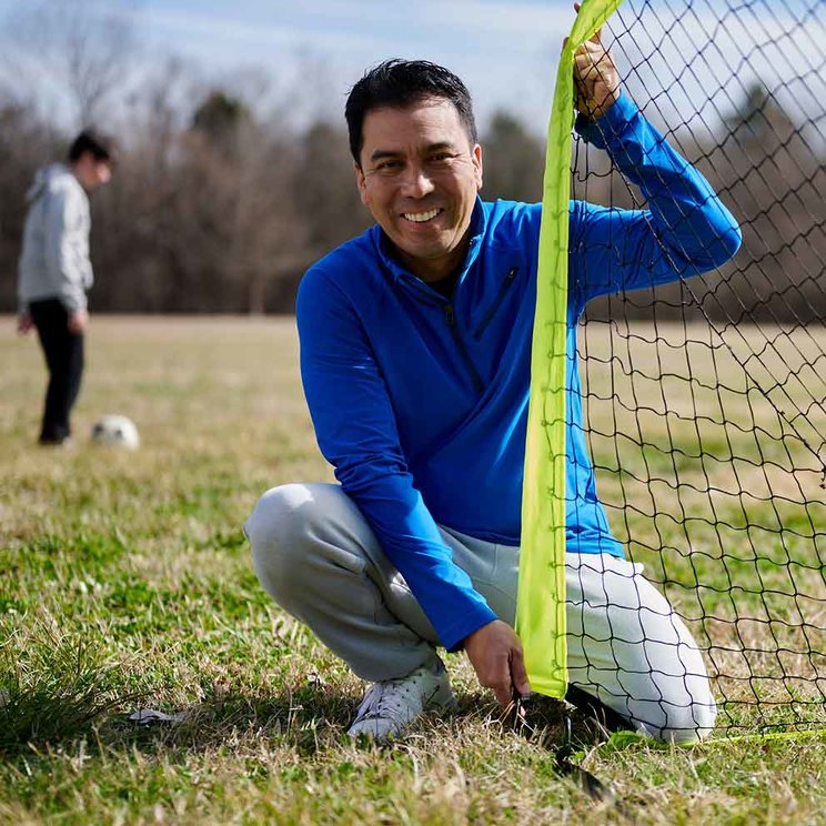 Mark on soccer field setting up net.